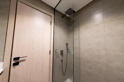 a shower with a glass door in a bathroom at Bright & Stylish 1-Bedroom at Empire Residence in Dubai