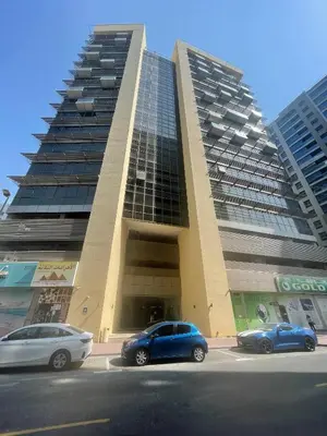 two cars parked in a parking lot in front of a building at Luxurious 1 Bedroom Apartment in Heart of Dubai in Dubai