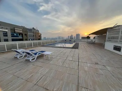 a rooftop with a pool and chairs on a building at Luxurious 1 Bedroom Apartment in Heart of Dubai in Dubai