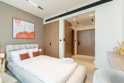 a bedroom with a large white bed in a room at HAVN - Bright & Cozy Studio at Binghatti Azure JVC in Dubai