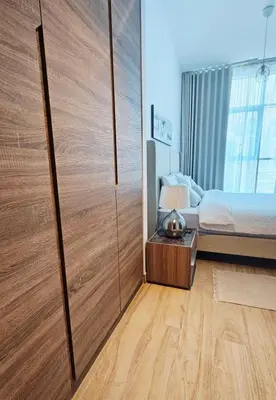 a bedroom with a bed and a large wooden closet at Modern New Sea View 1 BR Apartment in Dubai