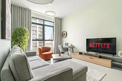 a living room with a couch and a tv at VayK - Prestigious 1BR Apartment in Dubai Hills Estate in Dubai