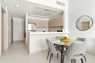 a kitchen and dining room with a table and chairs at VayK - Prestigious 1BR Apartment in Dubai Hills Estate in Dubai