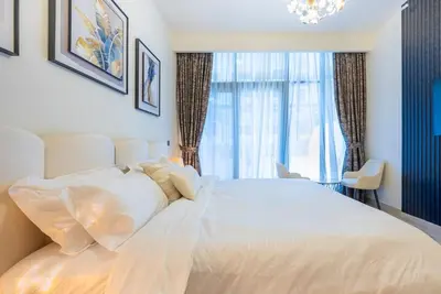 a white bed in a room with a window at Cozy Studio with a huge terrace in Dubai