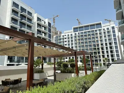 a patio with chairs and umbrellas in front of buildings at Cozy Studio with a huge terrace in Dubai