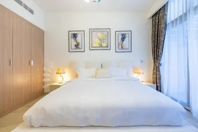 a bedroom with a large white bed and a window at Cozy Studio with a huge terrace in Dubai