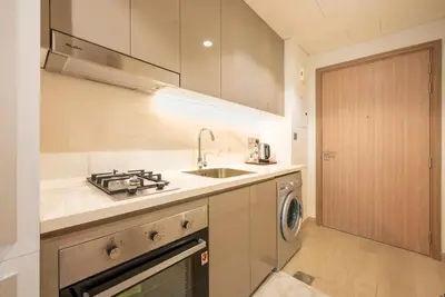 a kitchen with a sink and a washing machine at Cozy Studio with a huge terrace in Dubai