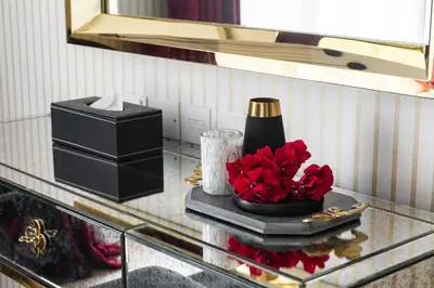 a glass table with a vase with red flowers on it at Lux Penthouse 4BR Apartment with Iconic Marina Views in Sadaf2 JBR by Simply Comfort in Dubai
