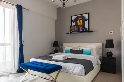 a bedroom with a king sized bed with a blue chair at Lux Penthouse 4BR Apartment with Iconic Marina Views in Sadaf2 JBR by Simply Comfort in Dubai