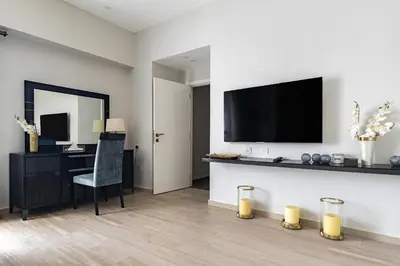 a living room with a desk and a television on a wall at Lux Penthouse 4BR Apartment with Iconic Marina Views in Sadaf2 JBR by Simply Comfort in Dubai