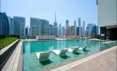 a swimming pool with chairs and a city skyline at Water Front, State of the Art Furniture, Burj View sleeps 4 in Dubai