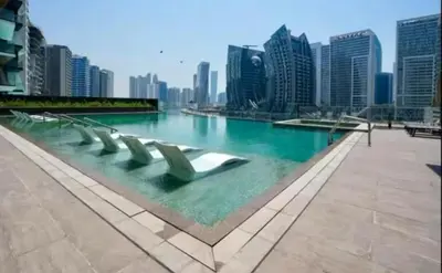 a pool of water with chairs in the middle of a city at Water Front, State of the Art Furniture, Burj View sleeps 4 in Dubai