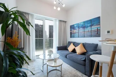 a living room with a blue couch and a table at Reva 1BR - Downtown Living with Burj Khalifa View in Dubai