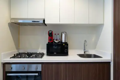 a kitchen counter with a sink and a microwave at Reva 1BR - Downtown Living with Burj Khalifa View in Dubai