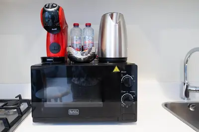 a microwave on a counter next to a stove at Reva 1BR - Downtown Living with Burj Khalifa View in Dubai