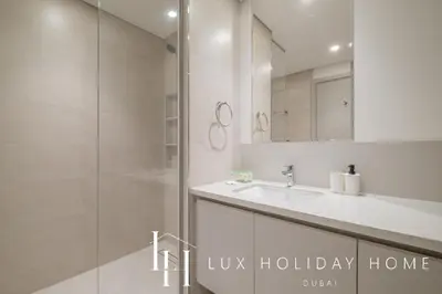 a bathroom with a shower and a sink and a mirror at LUX The Creek Palace Residence Suite 2 in Dubai