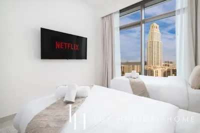 a white bedroom with a view of the city at LUX The Creek Palace Residence Suite 2 in Dubai