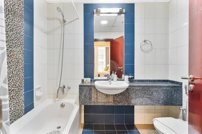 a bathroom with a sink and a tub and a toilet at Bright 1BR with Canal Views Near Burj Khalifa in Dubai