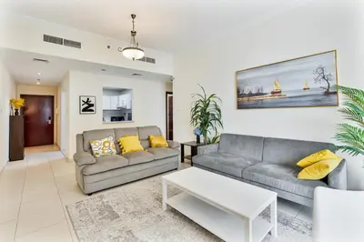 a living room with two couches and a table at Bright 1BR with Canal Views Near Burj Khalifa in Dubai