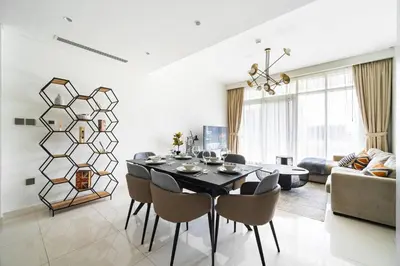 a dining room with a black table and chairs at SettlerHomes - Sunrise Beach Bliss With Private Beach in Dubai