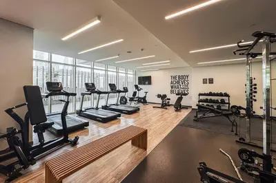a gym with treadmills and machines in a room at SettlerHomes - Sunrise Beach Bliss With Private Beach in Dubai