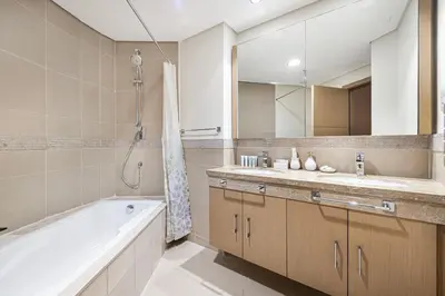 a bathroom with a tub and a sink and a mirror at Charming 3BR Sea View 37th Floor in Dubai