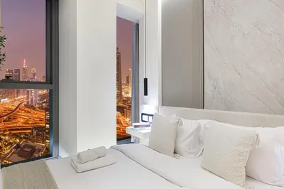 a bedroom with a white bed with a view of a city at Charming 3BR Sea View 37th Floor in Dubai