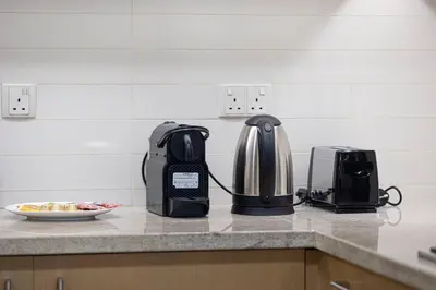 a coffee maker and a toaster on a kitchen counter at Charming 3BR Sea View 37th Floor in Dubai