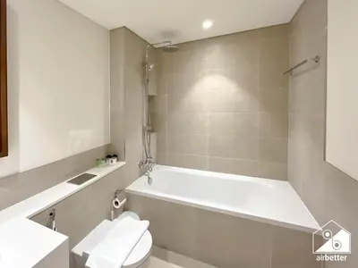 a bathroom with a white tub and a toilet at Beachfront 1B at Palm Jumeirah with Balcony & Views in Dubai