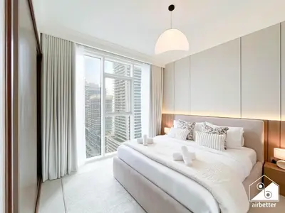 a bedroom with a large bed with a large window at Beachfront 1B at Palm Jumeirah with Balcony & Views in Dubai
