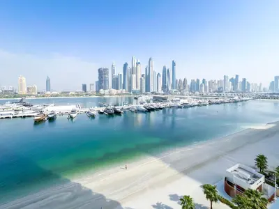 a marina with boats in the water and a city at Beachfront 1B at Palm Jumeirah with Balcony & Views in Dubai