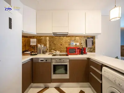 a kitchen with white cabinets and a red microwave at Le Chateau Vacation Homes,Fashion Avenue Residence in Dubai