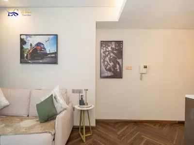 a living room with a couch and two pictures on the wall at Le Chateau Vacation Homes,Fashion Avenue Residence in Dubai