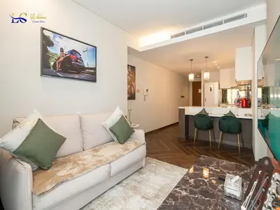 a living room with a couch and a kitchen at Le Chateau Vacation Homes,Fashion Avenue Residence in Dubai