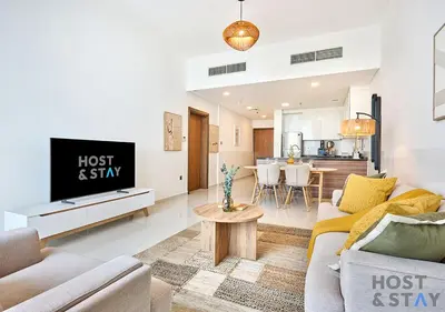 a living room with a couch and a tv at Radiant & Sunny Living - 1BR in ORchid DAMAC Hills in Dubai