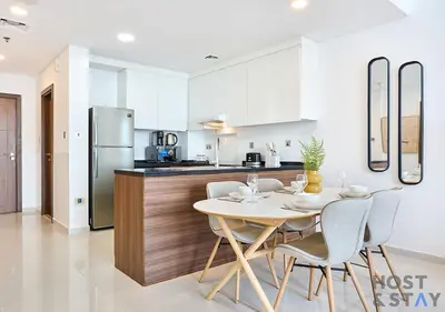 a kitchen and dining room with a table and chairs at Radiant & Sunny Living - 1BR in ORchid DAMAC Hills in Dubai