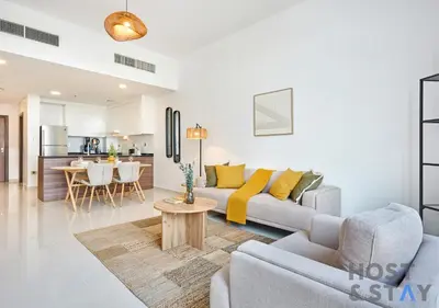 a living room with a couch and a table at Radiant & Sunny Living - 1BR in ORchid DAMAC Hills in Dubai
