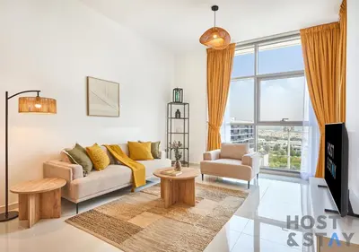 a living room with a couch and a tv at Radiant & Sunny Living - 1BR in ORchid DAMAC Hills in Dubai