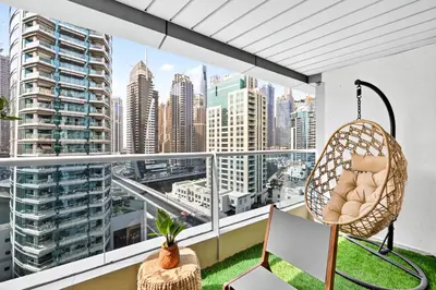 a chair on a balcony with a view of a city at Luxury 2BR Marina View-walking distance to JBR beach, marina mall & metro in Dubai