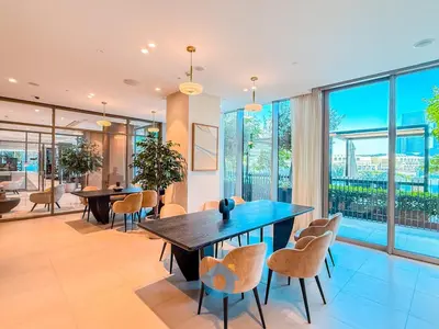 a dining room with a table and chairs and windows at Next to Burj Khalifa & Dubai Mall Luxury 2BR Grande Signature - Like Home in Dubai