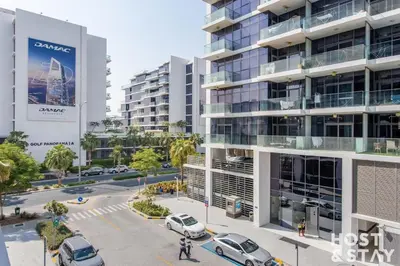 an aerial view of a parking lot in front of a building at Modern Studio in Loreto 1A, Damac Hills in Dubai