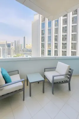 a room with two chairs and a table and windows at AquaVista Ensuite Room - Lakeview in Dubai