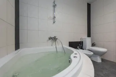 a bathroom with a bath tub with a toilet at AquaVista Ensuite Room - Lakeview in Dubai