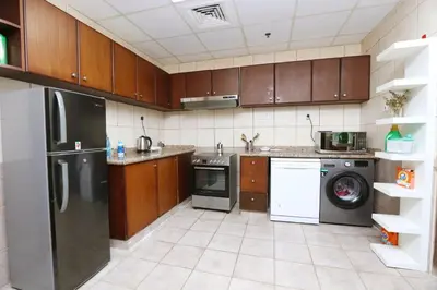 a kitchen with a refrigerator and a dishwasher at AquaVista Ensuite Room - Lakeview in Dubai