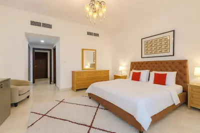 a bedroom with a large white bed with red pillows at AquaVista Ensuite Room - Lakeview in Dubai