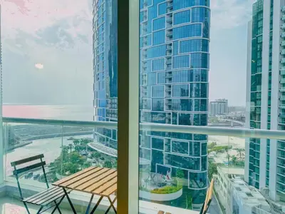 a balcony with a table and a view of a building at Walk to JBR Marina Beach & Tram! Luxury Family 3BD, Stunning Views in Dubai