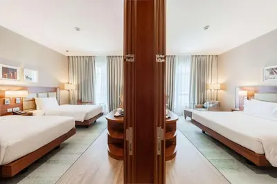a hotel room with two beds and a living room at Hilton Garden inn Dubai Jumeirah in Dubai