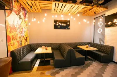 a restaurant with a couch and two tables and lights at Hilton Garden inn Dubai Jumeirah in Dubai