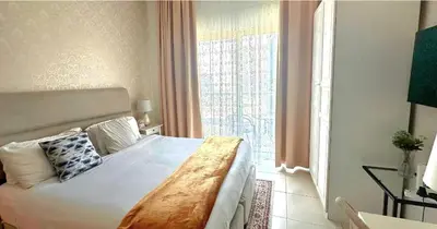 a bedroom with a bed and a large window at MARINA VIEWs STUDIO APARTMENT in Dubai