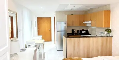 a kitchen with a counter and a refrigerator at MARINA VIEWs STUDIO APARTMENT in Dubai